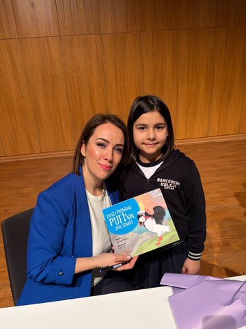 Okul buluşmasında kitabını imzalayan Elif Ezgi Balıkçı ve genç bir okur